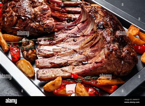 Delicious Roasted Ribs With Garnish On Table Closeup Stock Photo Alamy