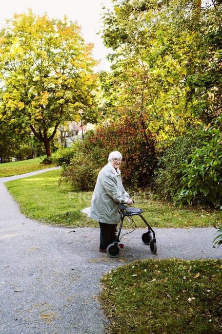 Senior Woman Using Walking Frame Walking In Park Outdoors Stockholm