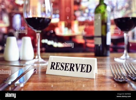 Restaurant Reserved Table Sign With Places Setting And Wine Glasses