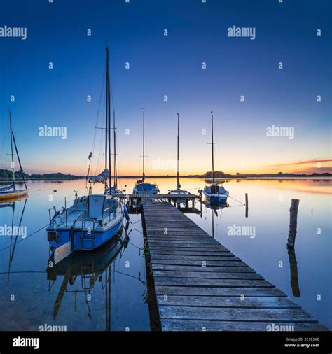 Morning Glow At Schaalsee Wooden Jetty With Sailing Boats Schaalsee