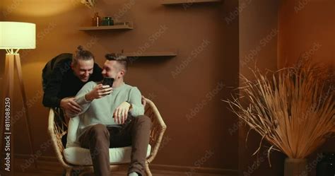 Cute Male Gay Couple Spend Time Sitting Chair Floor Use Smartphone