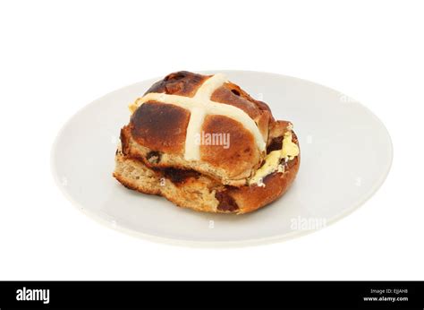 Single Toasted And Buttered Hot Cross Bun On A Plate Isolated Against