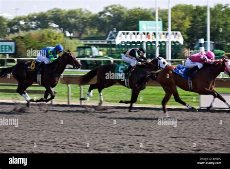 Three colourful horse racers passing at Arlington Park racetrack ...