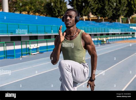 African Athlete Doing Warm Up Exercises On Athletics Track Stock Photo