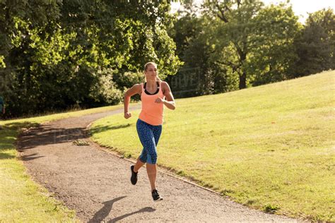 Young Female Runner Running Along Park Path Stock Photo Dissolve