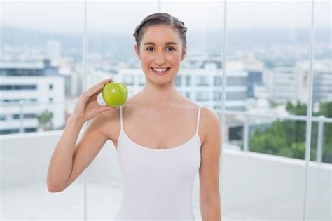 Premium Photo Cheerful Sporty Brunette Holding Green Apple