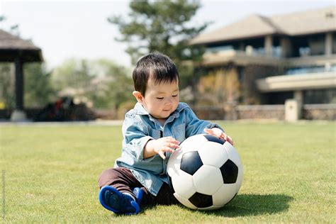 Baby Boy Playing Football On Grass Del Colaborador De Stocksy Maahoo