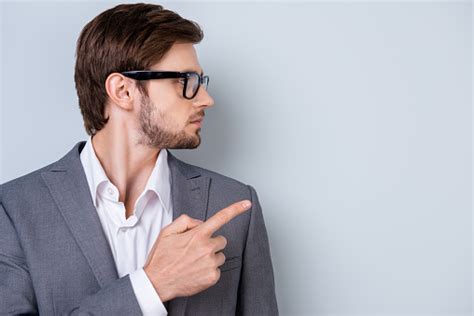 Side View Portrait Of Young Businessman In Glasses And Formalwear Pointing On Copyspace Stock