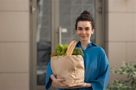 Donna Del Colpo Medio Che Tiene Generi Alimentari Foto Gratis