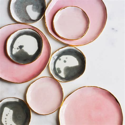 Four Pink And Black Plates Sitting On Top Of A White Countertop Next To