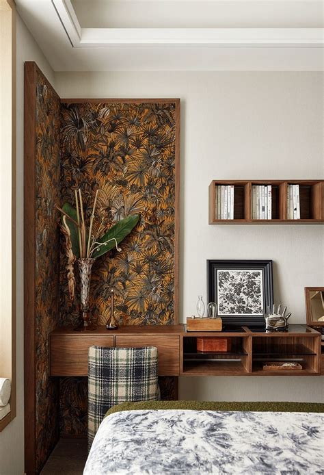 A Bed Room With A Neatly Made Bed Next To A Wall Mounted Shelf And Plant