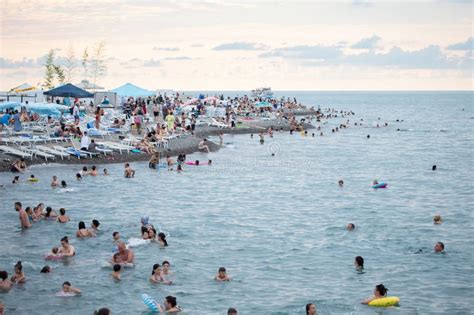 People Sunbathe And Swim On The Crowded Beach Of The Black Sea Resort