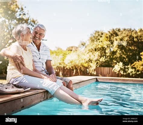 Senior Couple Hug And Smile By Swimming Pool For Relax Love Or