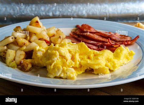 American Breakfast Food Scrambled Eggs With Home Fries And Crispy Bacon