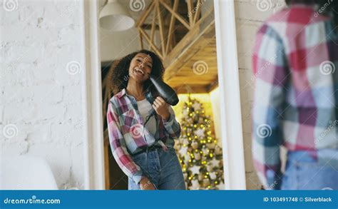 Curly Funny African American Girl Dancing And Singing With Hair Dryer