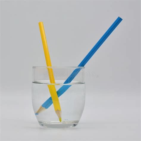 Refraction of light. Shown in a glass of water with colored pencils , # ...