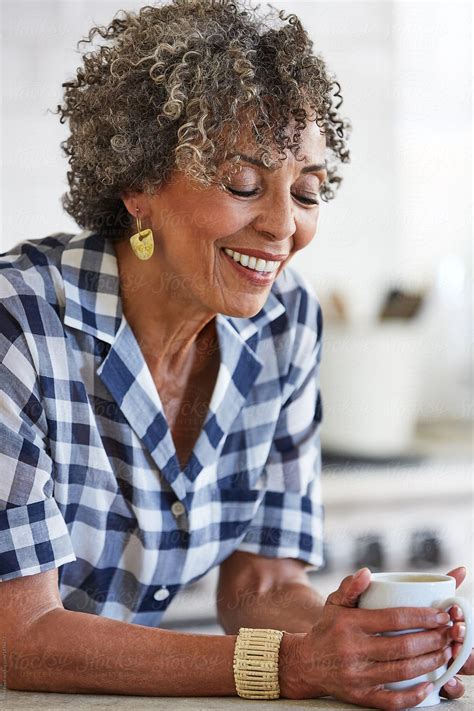 «senior African American Woman In Her Kitchen Drinking Coffee Del