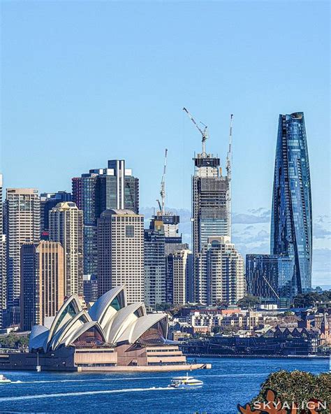 The City Skyline Is Seen From Across The Water With Boats In It And