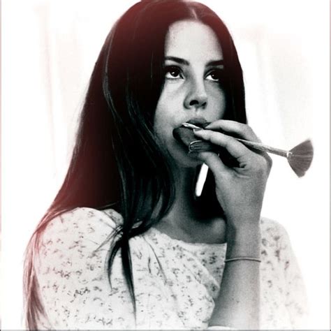 A Black And White Photo Of A Woman Holding A Brush To Her Mouth While