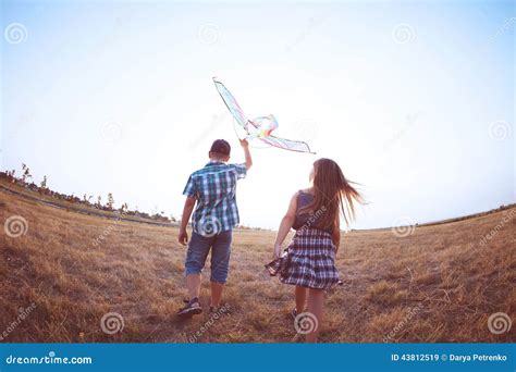 Gar On Heureux Et Petite Fille Courant Avec Le Cerf Volant Lumineux Sur