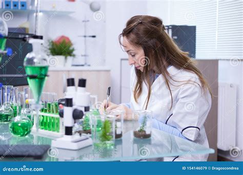 Photo Of Mature Female Scientist Writing Notes On Her Notebook After
