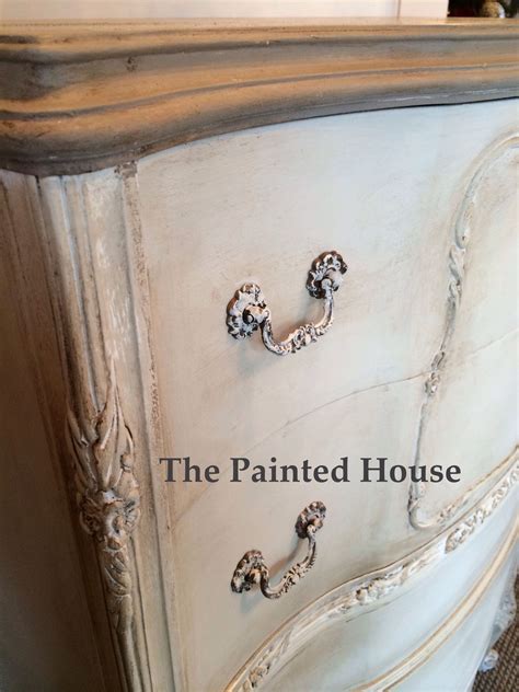 An Old White Painted Dresser With Ornate Handles