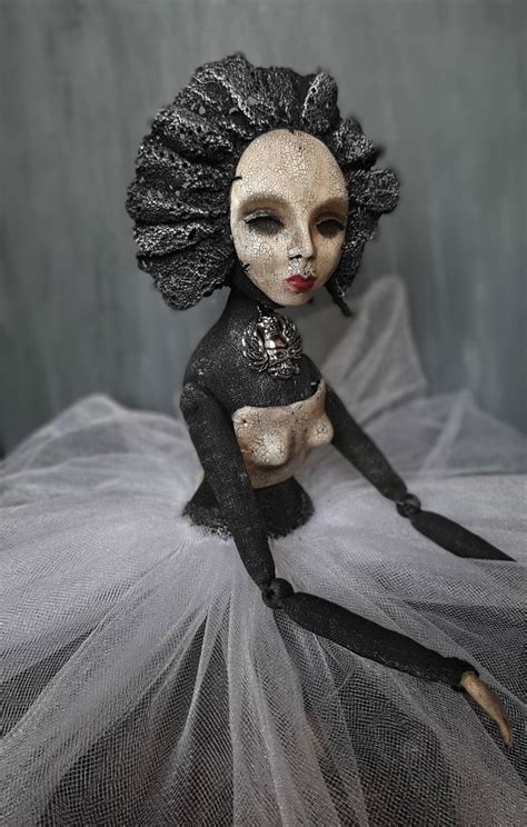 A Black And White Doll Sitting On Top Of A Tulle