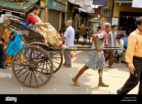 City Life Hand Rickshaw Puller Pulling With Passenger On Street Of