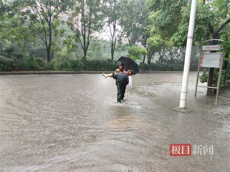 雨中暖心一幕：七旬太婆蹚水乘公交，综合执法队员抱她转乘 极目新闻