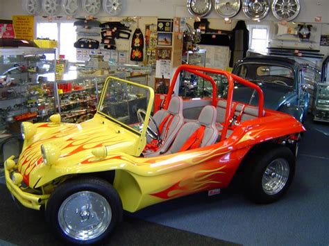 An Orange And Yellow Car With Flames Painted On It S Side In A Showroom