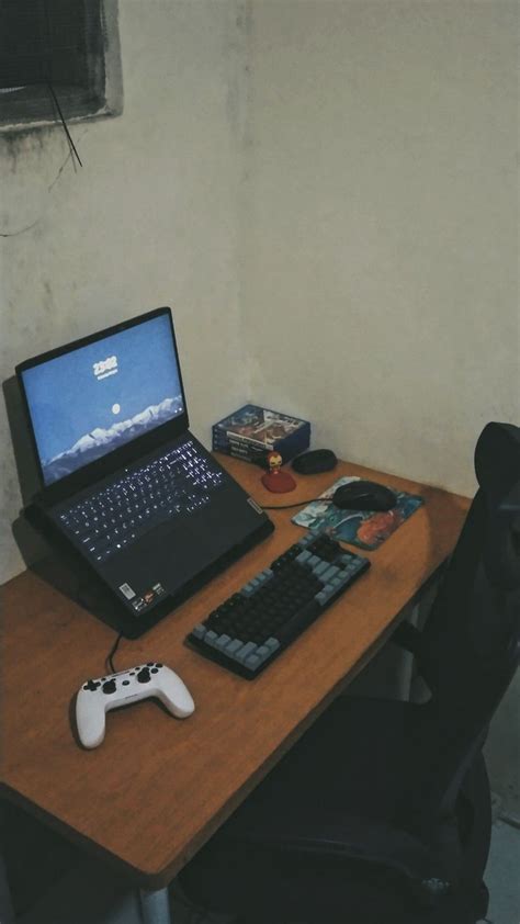 An Open Laptop Computer Sitting On Top Of A Wooden Desk Next To A Game