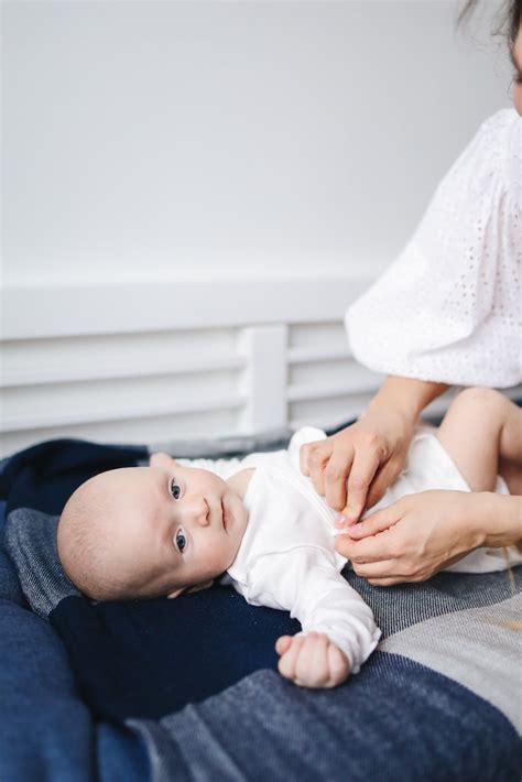 Baby in White Onesie Lying on Bed · Free Stock Photo