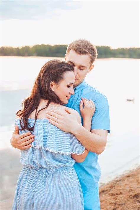 Young Couple In Love Hug Each Other At The Lake Outdoor In Summer Day