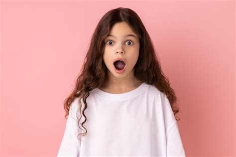 Niña sorprendida mirando a la cámara con la boca abierta y ojos grandes