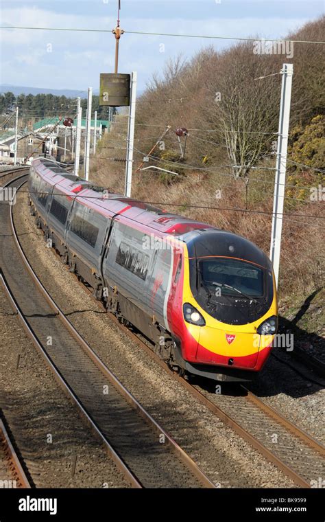 Virgin Pendolino train rounding a curve on the West Coast Main Line at ...