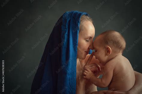 Beautiful Long Haired Mother In Red And Blue Dresses With A Naked Baby Looks Like Madonna Image