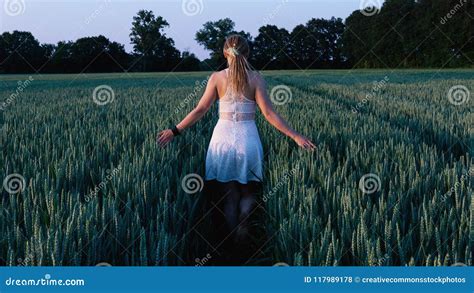 Woman In White Sleeveless Mini Dress Standing Between Grass Field