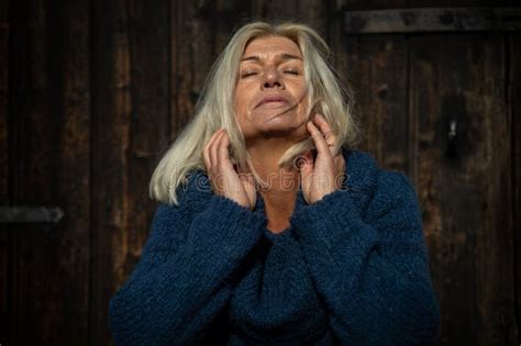 Blonde Woman In Her Mid Fifties Wearing A Wide Blue Knitted Sweater Stock Image Image Of