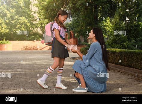 Mother Saying Goodbye To Her Daughter Before School Outdoors Stock