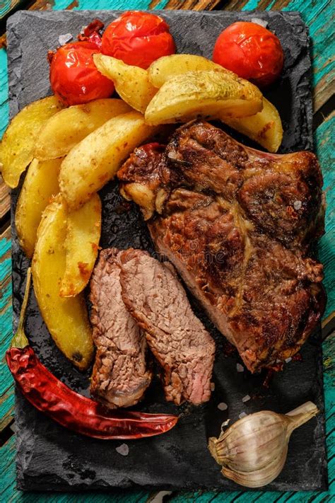 Saftiges Getanes Rindfleisch Des Steaks Gut Mit Potatos Und Tomaten