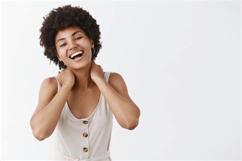 Fille élégante heureuse insouciante posant contre le mur blanc Photo