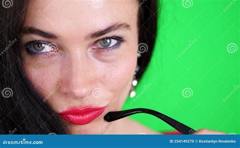 Green Background Chromeakey Portrait Of A Brunette Woman With Red Lips In Stylish Glasses