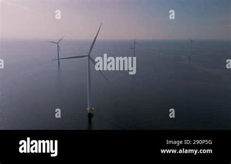 Majestic Windmill Turbines Stand Tall Against The Serene Backdrop Of