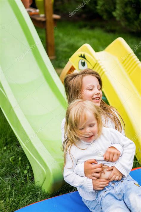 niños viajan desde el tobogán infantil las hermanas juegan juntas en