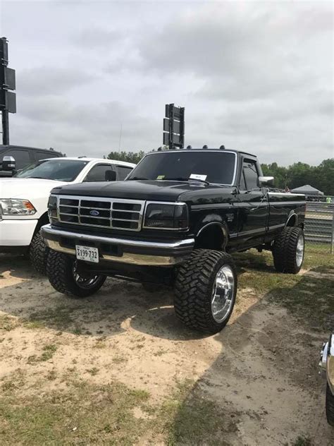 Two Pickup Trucks Parked Next To Each Other