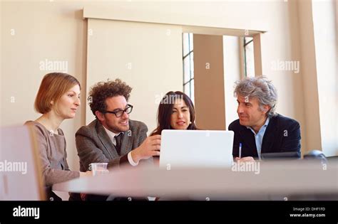 Office Colleagues In Meeting Using Laptop Stock Photo Alamy