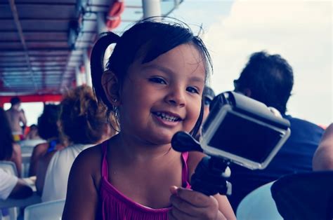 Premium Photo Portrait Of Cute Smiling Girl Holding Camera