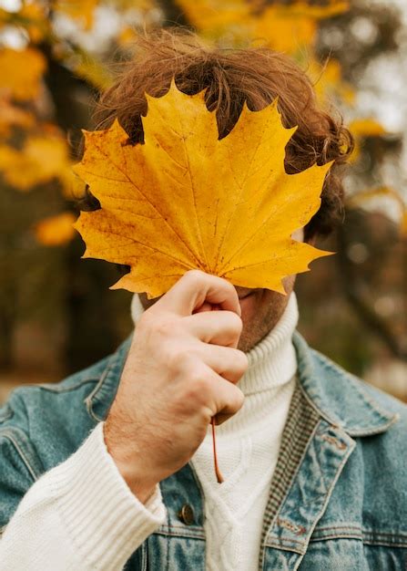 Hombre Que Cubre Su Rostro Con Una Hoja Amarilla Foto Premium