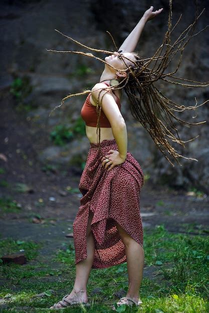 Belle fille avec des dreadlocks habillé style hippie pose à l extérieur