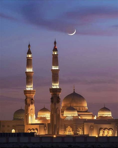 Two Large White Buildings With Lights On Them At Night In Front Of A